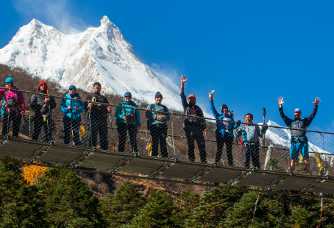 Trekkers crossing a suspension bridge high above the Budhi Gandaki gorge
