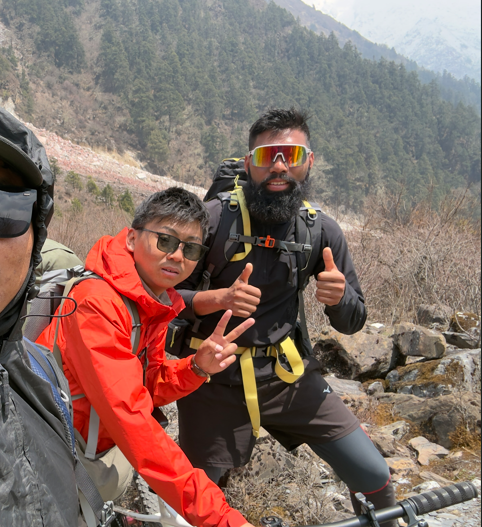 A guide and a trekker resting together on a mani wall